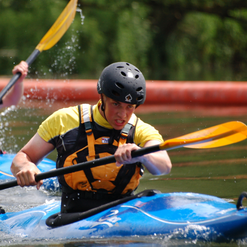 Young male participant kayaking on river